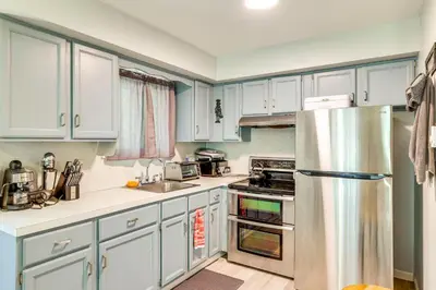 a kitchen with white cabinets and a stainless steel refrigerator at Walk to Lake Carobeth Gem in Pocono Country Place in Tobyhanna
