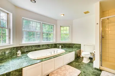 a bathroom with a tub and a toilet at Serene Hudson Valley Escape with Pool and Grill in Carmel