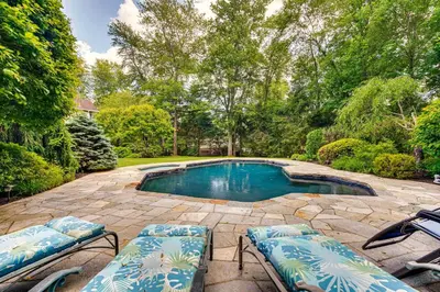 a swimming pool with two lounge chairs and a patio at Serene Hudson Valley Escape with Pool and Grill in Carmel