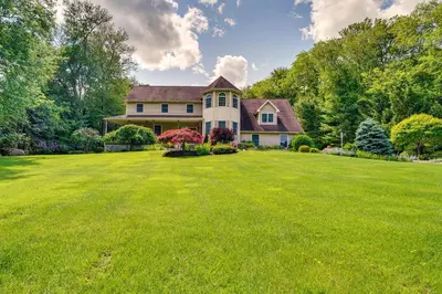 a house with a large yard with green grass at Serene Hudson Valley Escape with Pool and Grill in Carmel