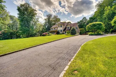 an empty road in front of a house at Serene Hudson Valley Escape with Pool and Grill in Carmel