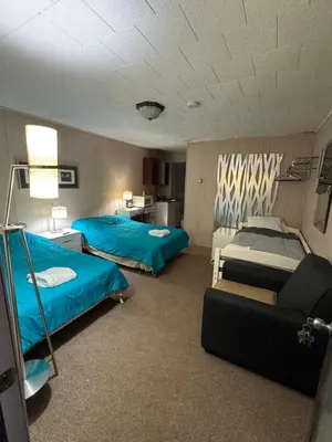 a hotel room with two beds and a couch at West Wind Motel in Fleischmanns