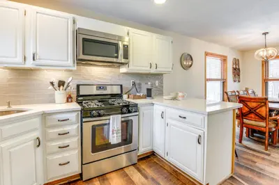 a kitchen with white cabinets and a stove at 3 min to Mt Snow with FREE Shuttle! Family-Size fun, Wood fireplace, 2 living rooms, Arcades in Dover
