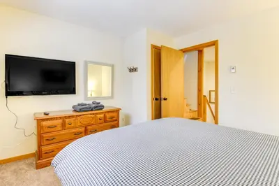 a bedroom with a bed and a tv on a wall at 3 min to Mt Snow with FREE Shuttle! Family-Size fun, Wood fireplace, 2 living rooms, Arcades in Dover