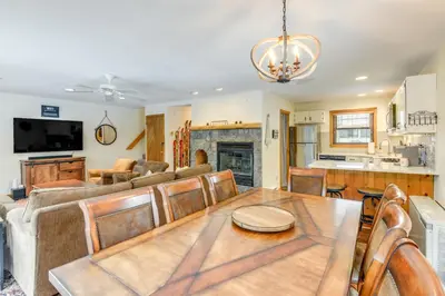 a dining room and living room with a table and a couch at 3 min to Mt Snow with FREE Shuttle! Family-Size fun, Wood fireplace, 2 living rooms, Arcades in Dover