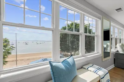 a living room with large windows looking out at the beach at Beachfront Apartment - 8 min from downtown in New Haven