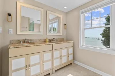 a bathroom with a sink and two windows at Beachfront Apartment - 8 min from downtown in New Haven