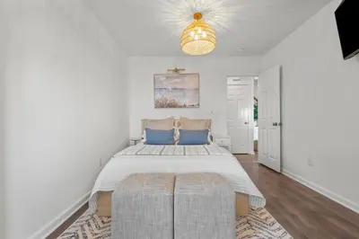 a bedroom with a large bed and a chandelier at Beachfront Apartment - 8 min from downtown in New Haven