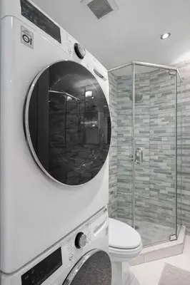a bathroom with a toilet and a glass shower at Stylish East Side Escape Steps from Fun in New York