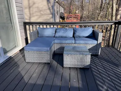 a couch sitting on a deck with blue pillows at Explore Poconos with Fire pit, Games, Grill in Tobyhanna