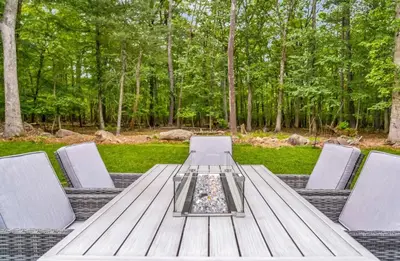 a wooden table with four chairs around it at Dine Outdoors, Dream Indoors 5BR in East Stroudsburg