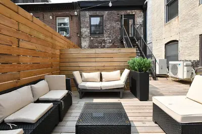 a patio with couches and chairs on a wooden deck at Boho Rustic Escape with Masssive Terrace in Midtown in New York