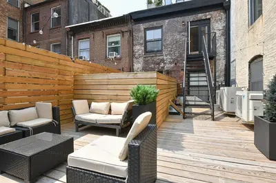 a patio with chairs and tables on a wooden deck at Boho Rustic Escape with Masssive Terrace in Midtown in New York