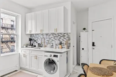 a white kitchen with a washing machine in it at Style & Comfort 3 Rooms -15 min from NYC in West New York