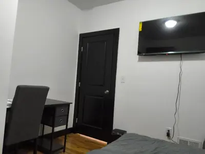 a room with a bed and a desk and a black door at Log Comfort in Newark