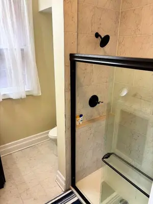 a shower with a glass door in a bathroom at Nintendo, Filtered H2O, Cafe, Central, Self-Check in Troy