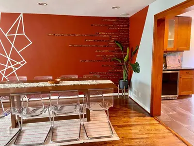 a dining room with a wooden table and chairs at Easy PATH&Bus access- NYC designer home & Terrace in Jersey City