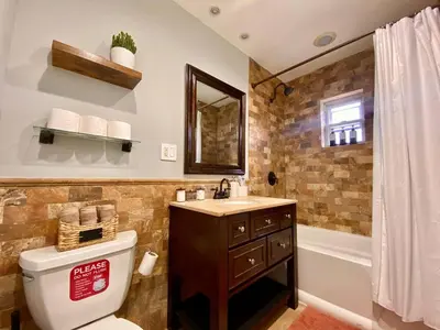 a bathroom with a toilet and a sink and a tub at Comfortable home close to Manhattan,Wall St & more in Jersey City