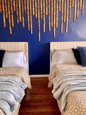 a bedroom with two beds and a blue wall at Comfortable home close to Manhattan,Wall St & more in Jersey City