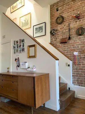 a room with a staircase and a brick wall at Airy brownstone penthouse duplex near Central Park in New York