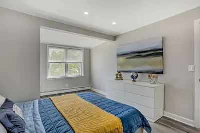 a bedroom with a bed and a painting on the wall at Cozy Lakefront House with a private dock and lake in Hopatcong
