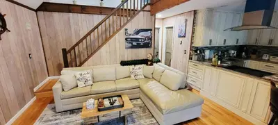 a living room with a couch and a kitchen at Getaway at the Hideout in Lake Ariel