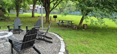 two benches and a picnic table in a park at Charming 3-BR Riverside country farmhouse Retreat Huge Yard & Fire Pit