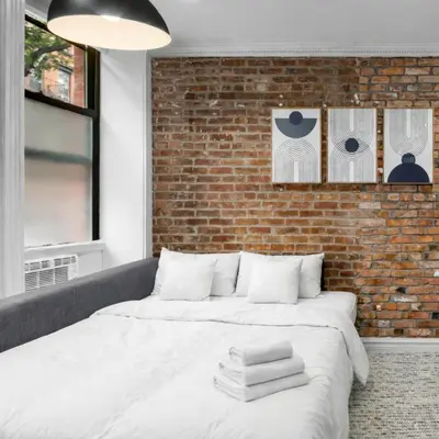 a bedroom with a bed with towels on it at Trendy East Village Escape in New York