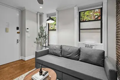 a living room with a couch and a table at Trendy East Village Escape in New York