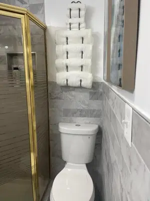 a bathroom with a toilet and a stack of towels at Susquehanna Waterfall Haven in Susquehanna