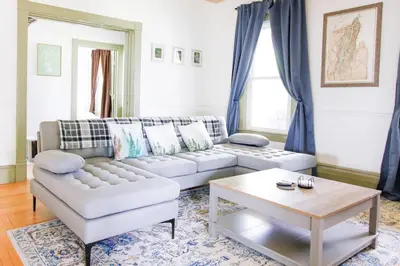 a living room with a couch and a table at Expansive Victorian close to Saratoga Springs and Lake George in Corinth
