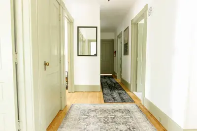 a hallway with a rug on the floor and a door at Expansive Victorian close to Saratoga Springs and Lake George in Corinth