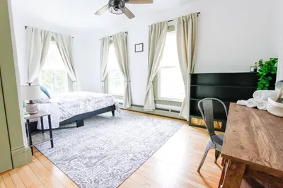 a bedroom with a bed and a table and chairs at Expansive Victorian close to Saratoga Springs and Lake George in Corinth