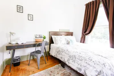 a bedroom with a bed with a desk and a bed sidx sidx sidx at Expansive Victorian close to Saratoga Springs and Lake George in Corinth