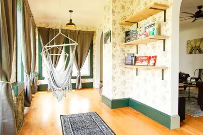 a living room with a hard wood floor and curtains at Expansive Victorian close to Saratoga Springs and Lake George in Corinth