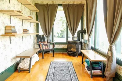 a living room with a table and a stove at Expansive Victorian close to Saratoga Springs and Lake George in Corinth