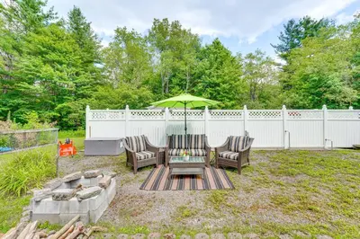 a backyard with two chairs and a table with an umbrella at 1 Mi to Hunter Mtn Cozy Unit on 6-Acre Property! in Hunter