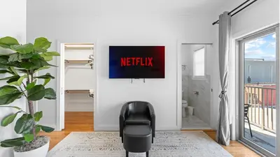 a black chair in a living room with a tv at Luxury Retreat Walk 2 PATH NYC in Mins Parking in Jersey City