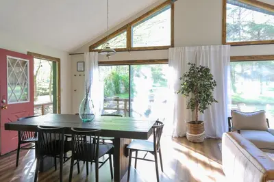 a dining room with a table and chairs and a couch at Luxurious Cabin by Lakes & Ski in Lake Ariel