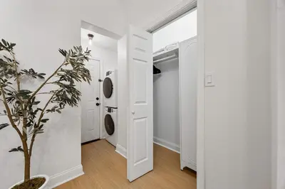 a hallway with white walls and a plant and a door at 2BR and 2BA in Historic Brownstone near Subway in New York