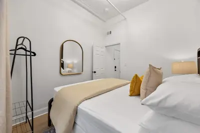 a white bedroom with a bed and a mirror at 2BR and 2BA in Historic Brownstone near Subway in New York