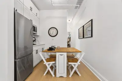 a kitchen with a table and a refrigerator at 2BR and 2BA in Historic Brownstone near Subway in New York