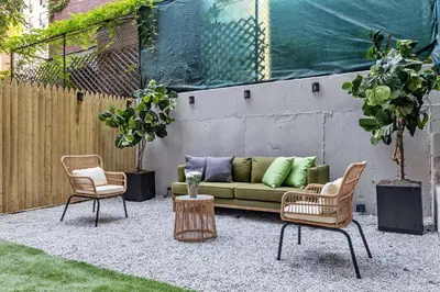 a patio with a couch and two chairs and a table at Brownstone 2 Bed with Private Backyard near Subway in New York