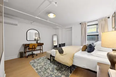 a bedroom with a bed and a desk in it at Brownstone 2 Bed with Private Backyard near Subway in New York