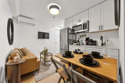 a kitchen and living room with a table and a couch at Brownstone 2 Bed with Private Backyard near Subway in New York