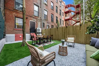 a patio with chairs and a table and a fence at Brownstone 2 Bed with Private Backyard near Subway in New York