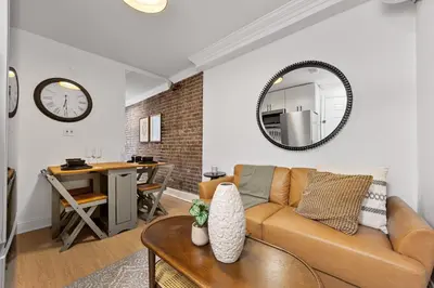a living room with a couch and a mirror at Brownstone 2 Bed with Private Backyard near Subway in New York