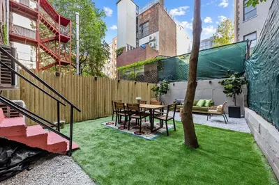 a small backyard with a table and a tree at Brownstone 2 Bed with Private Backyard near Subway in New York