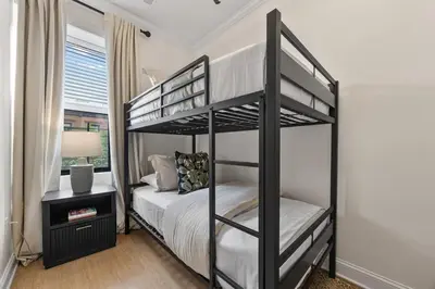 a bedroom with two bunk beds and a lamp at 3BR Harlem Stay with Washer with Dryer in New York