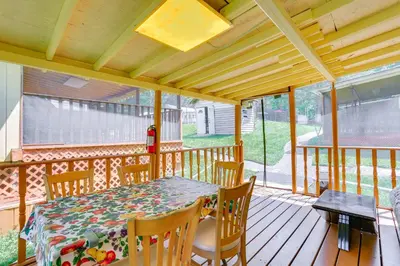 a porch with a table and chairs on a deck at 5 Mi to Swinging Bridge Reservoir Cabin with Porch! in Mongaup Valley